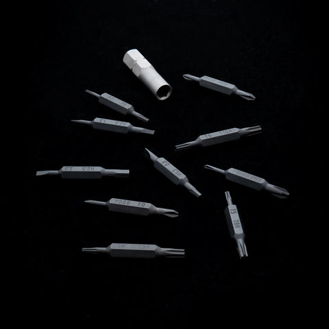 Black VERTEX Prism double-ended bits and adapter arranged on a black background
