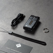 OMNI Beacon, charging cable, wrist strap and keyring arranged on a desk