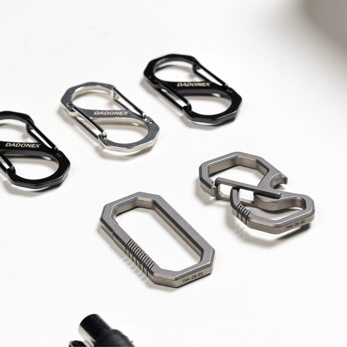 OMNI Link titanium clips and S-biners arranged on a white surface