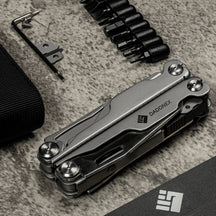 Folded OMNI Forge beside its driver bits and spare cutters