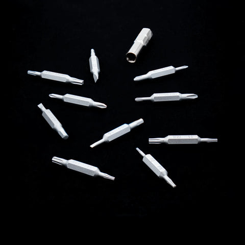 Silver VERTEX Prism double-ended bits and adapter arranged on a black background